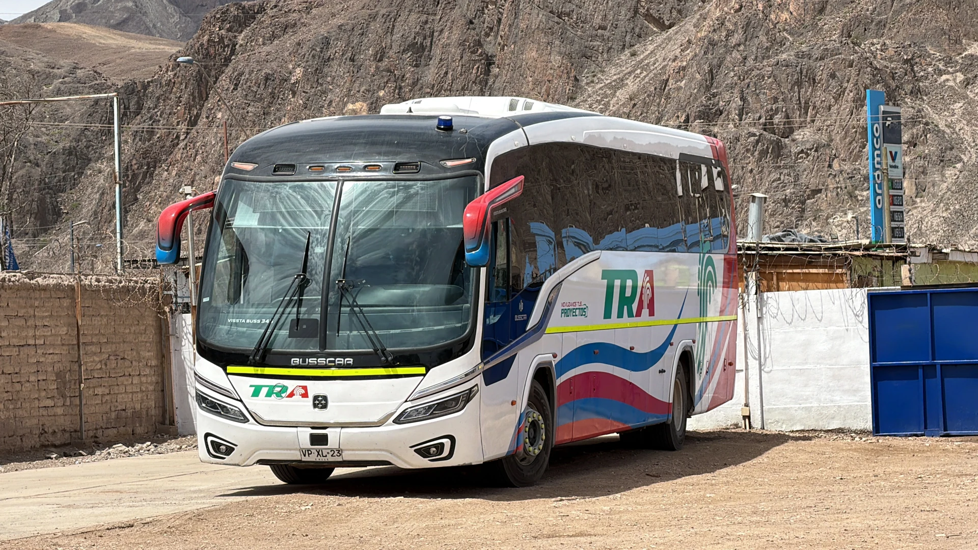 Bus TRA frente a un paisaje de cerros